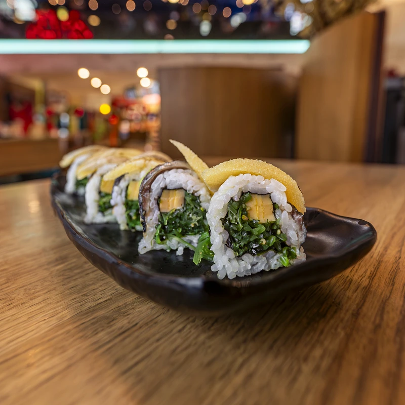 Kinjo sushi rolls on a black plate in the restaurant