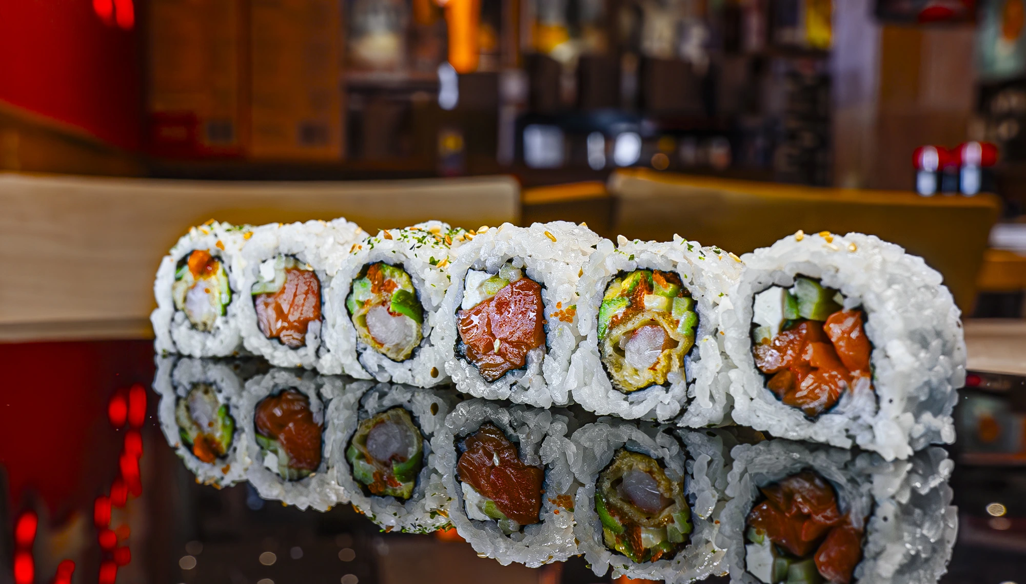 Kinjo sushi rolls on a reflective dark surface